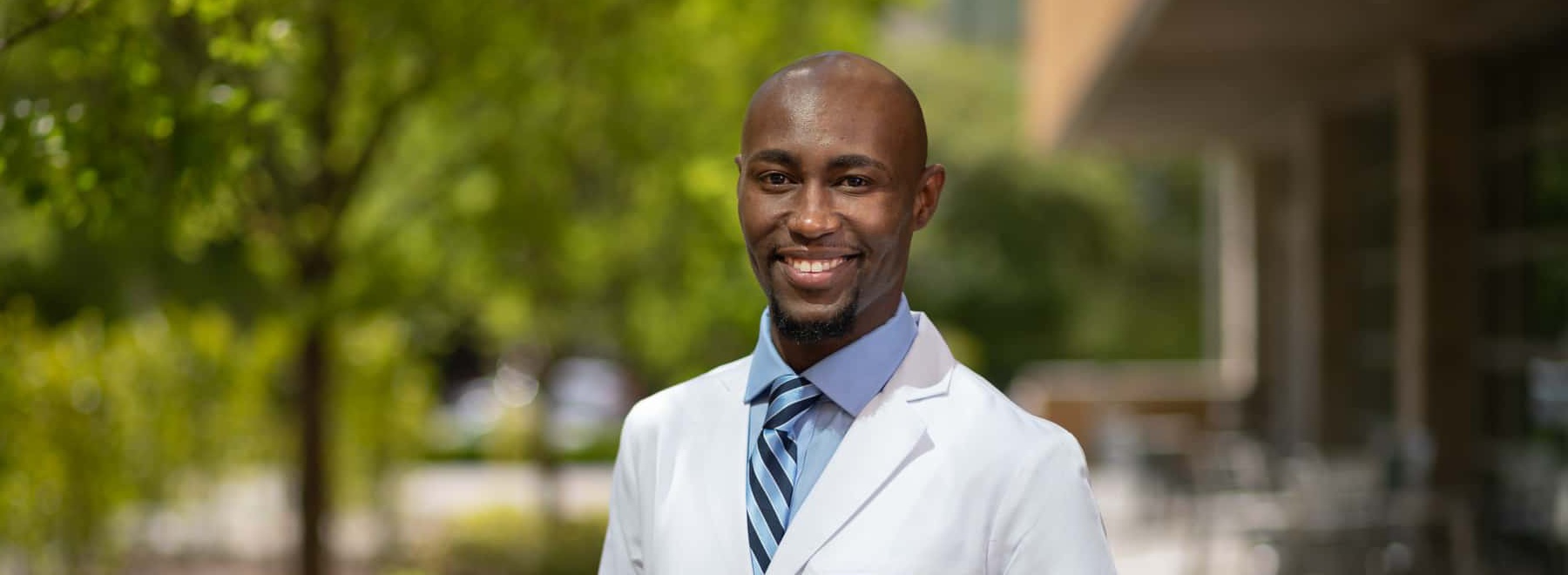 Male nursing student poses for a picture outside